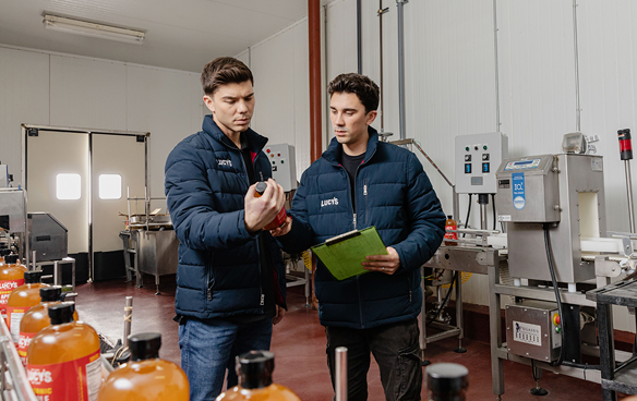 Two people examine bottled products.