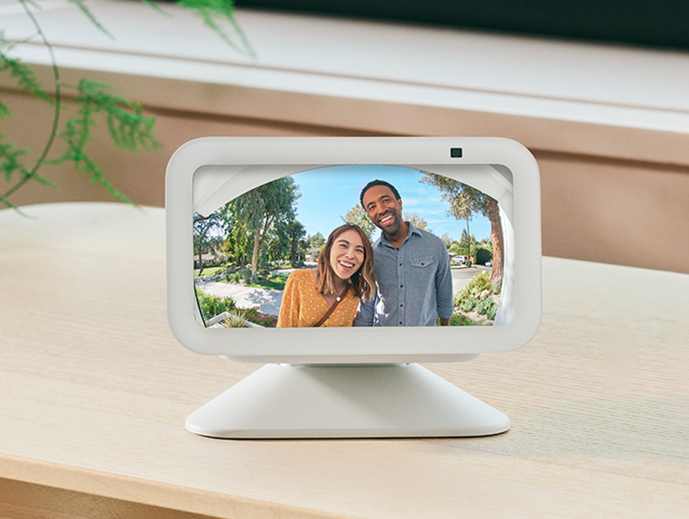 Two people appear smiling on the screen of an Amazon EchoShow device.